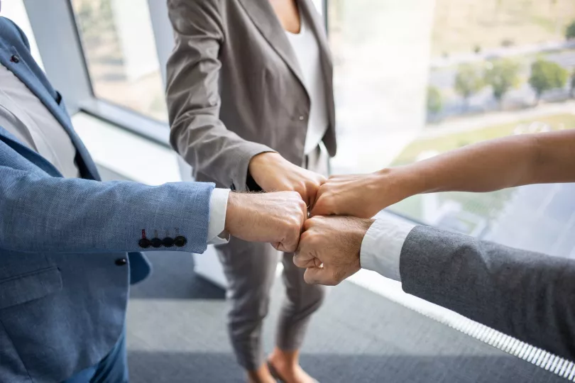 Close-up of a group of people fist-bumping